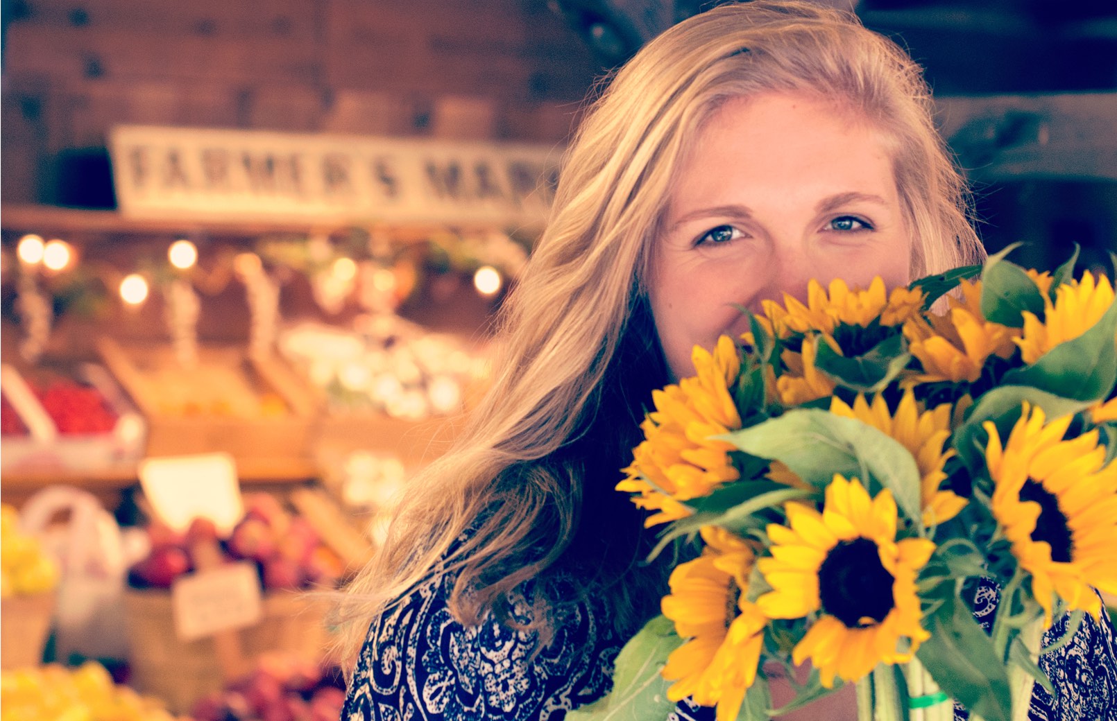 Frau kauft freudig Blumen am Wochenmarkt